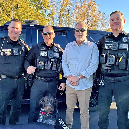 Police officers, police dog, and mayor standing together